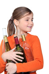 Little girl holding empty glass bottles