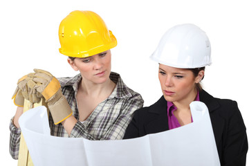 Construction worker looking at a plan with an engineer