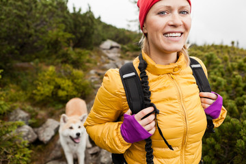 Fototapeta Happy woman hiking in mountains with akita dog, Poland obraz