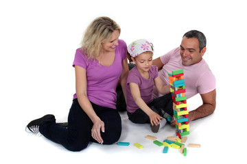 Parents stacking bricks with their daughter