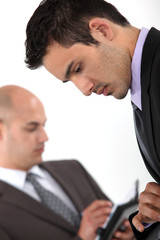 Fototapeta premium Two businessmen checking their schedules
