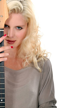 Beautiful woman peeking out from behind her guitar
