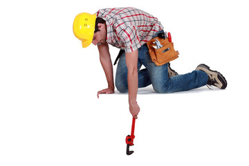 Worker reaching down with a wrench