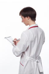 Молодая девушка делает запись в тетрадь