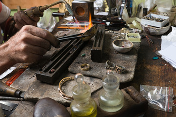Goldsmith working on an unfinished ring with flaming torch