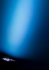 Foto op Plexiglas Licht en schaduw schijnwerper op blauwe muur