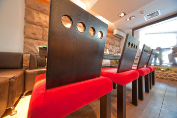 Sushi restaurant  with red chairs, focus on chairs
