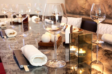 Glasses, candle on table in sushi restaurant, focus on glass