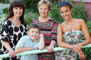 Grandmother, mother, daughter, brother near cottage