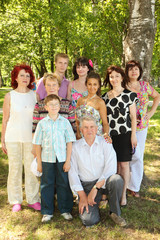 Obraz premium Big family of eight people pose at park