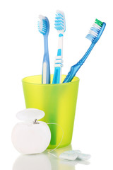 Toothbrushes, chewing gum and dental floss isolated on white