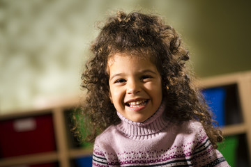 Happy child smiling for joy at camera in kindergarten