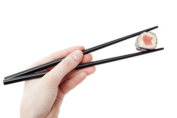 Hand holding maki sushi roll with chopsticks, isolated on white
