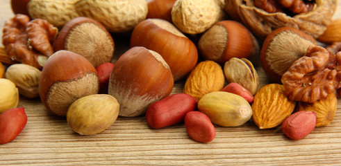 assortment of tasty nuts on wooden background