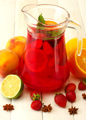 sangria in jar with fruits, on white wooden table
