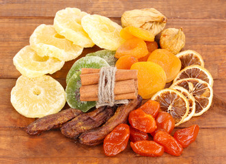 Dried fruits with cinnamon on wooden background