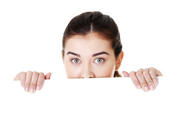 Shocked woman holding blank board