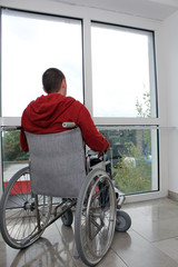 Rollstuhlfahrer vor Fenster