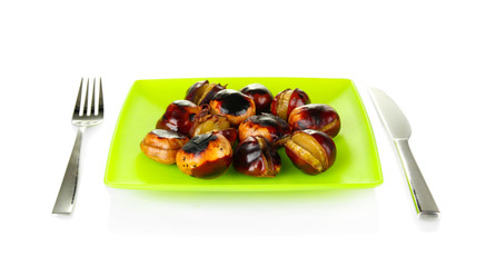 roasted chestnuts in the green plate with fork and knife