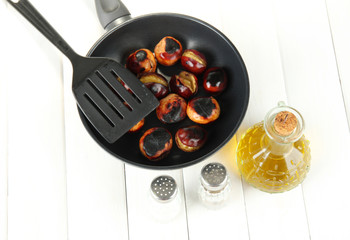 roasted chestnuts in the pan and decanter with oil, salt and