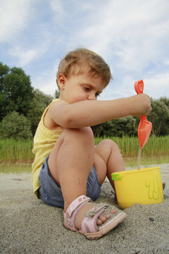 bambina paletta secchiello sabbia giocare