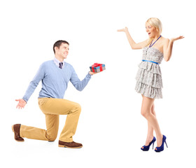 A male kneeling with a gift and excited female