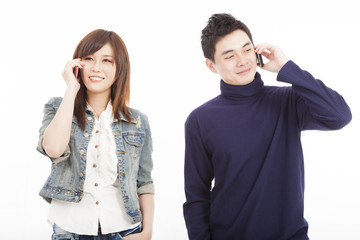 Young couple talking on mobile phone isolated on white