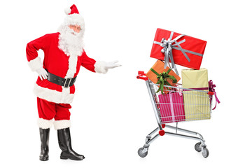 Santa Claus showing a shopping cart full of presents