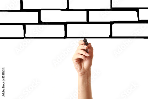 "Female hand drawing brick wall with black marker on the screen" Stock