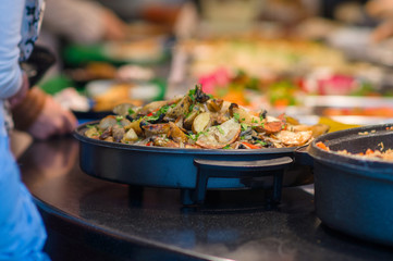 Salads and other dishes with vegetables and meat on table in res