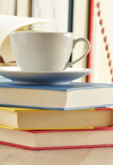 Composition with stack of books and cup of coffee