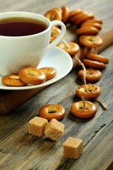 Cup of tea and small bagels with poppy seeds.