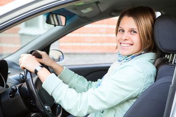 Driving happy woman holding steering wheel