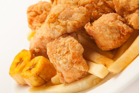 Fried chicken with french fries and banana fries close up