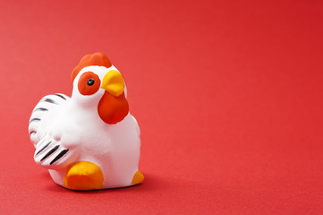 赤色の背景にトリの干支置物