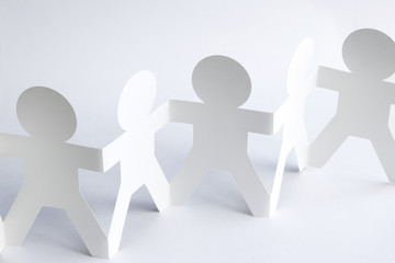 White paper chain people in a row holding hands. Teamwork