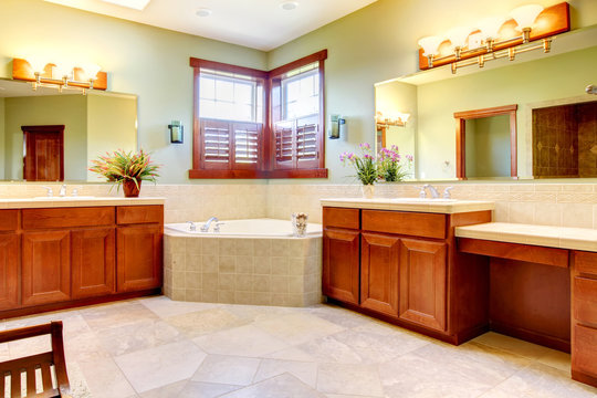 Large bathroom with double wood cabinets and corner tub.