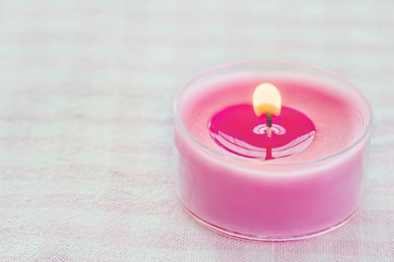 Obraz na płótnie Canvas Pink burning candle on a romantic soft background