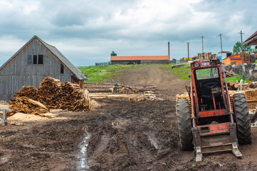 Fototapeta na wymiar Wood industry outdoorsm with red tractor
