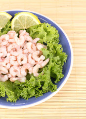 Delicious marinated shrimp in plate on bamboo mat