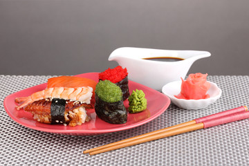delicious sushi served on plate on grey background