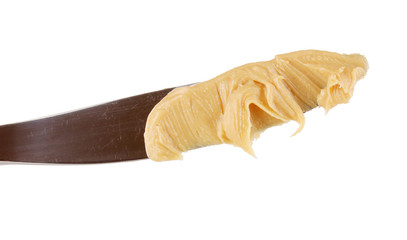 Delicious peanut butter on knife isolated on white close-up © Africa Studio