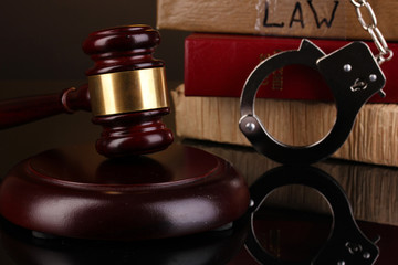 Gavel, handcuffs and.books on law isolated on black close-up