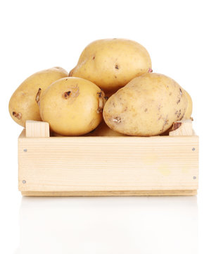 Ripe potatoes on wooden box isolated on white