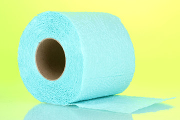 blue roll of toilet paper on green background