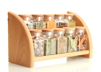 powder spices in glass jars on wooden shelf isolated on white