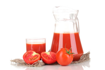 Tomato juice in pitcher and glass on sackcloth isolated on