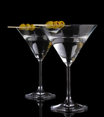 Martini glasses and olives isolated on black