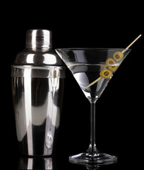 Martini glass with olives and shaker isolated on black