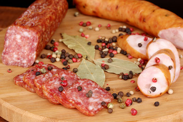 Tasty sausages on chopping board on browm background